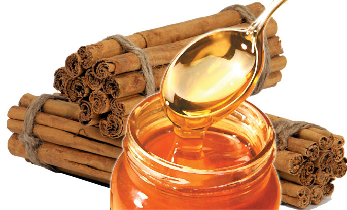 Honey and Cinnamon Can Improve Your Health. A jar of honey and a pile of cinnamon sticks. 