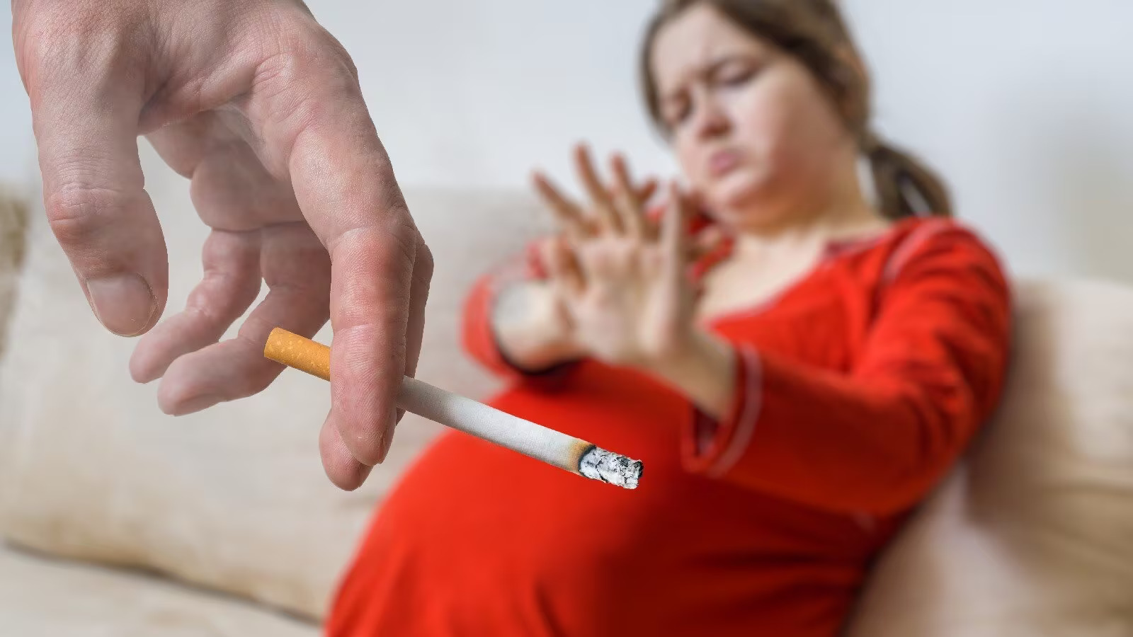 'Pregnant woman holding a lit cigarette with a red circle and slash symbol over it. The image highlights the risks and dangers associated with smoking while pregnant, including increased likelihood of premature birth, low birth weight, miscarriage, stillbirth, and various health complications for both the mother and the unborn child.