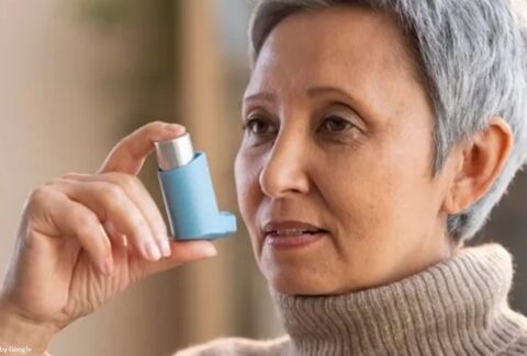 Old woman with chronic asthma using an inhaler
