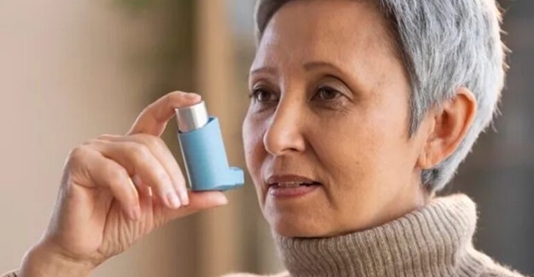 Old woman with chronic asthma using an inhaler