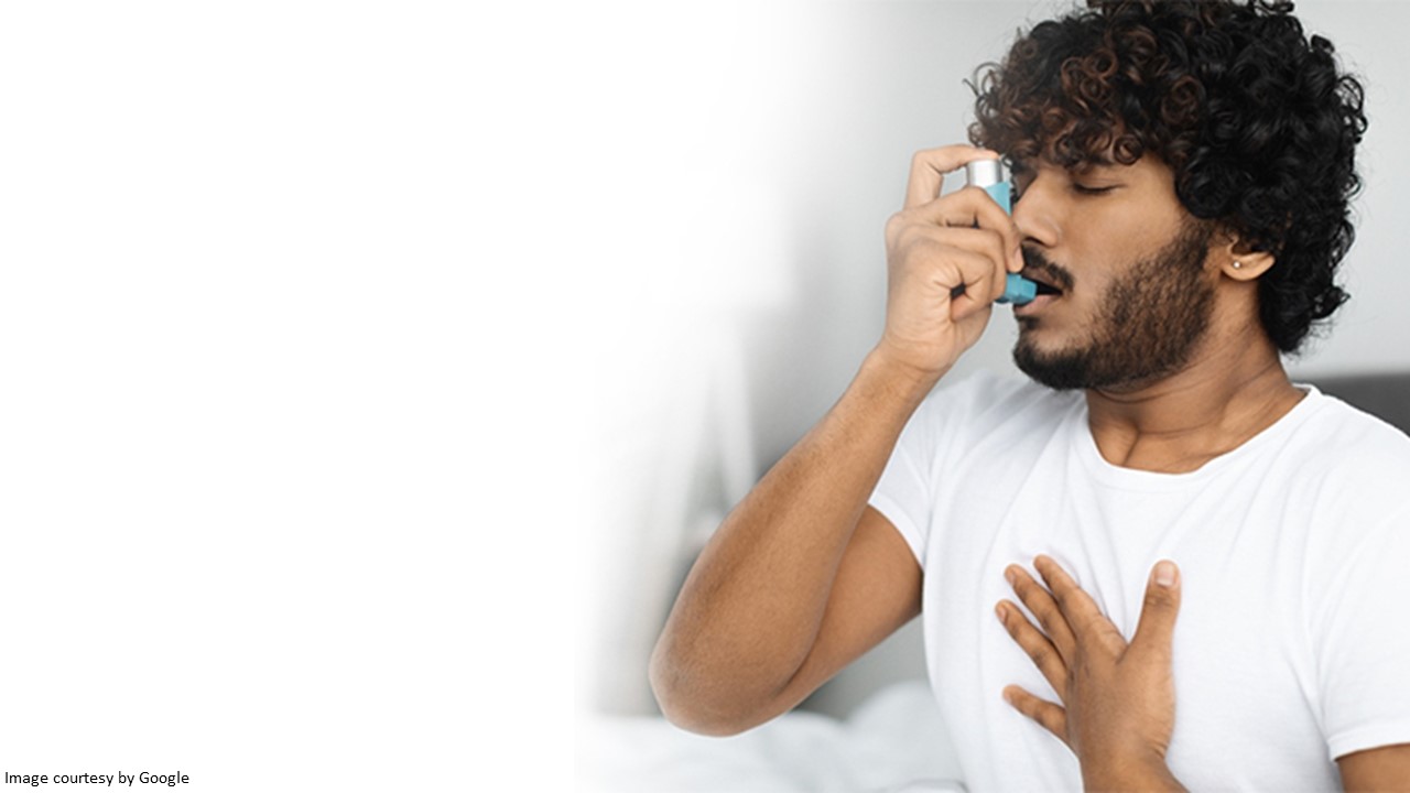 Young man using an inhaler to manage chronic asthma.