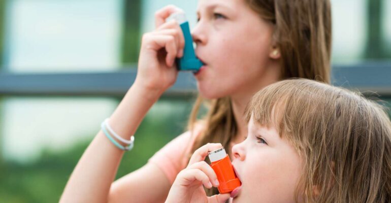 Image of person experiencing common asthma symptoms such as wheezing, shortness of breath, and coughing.