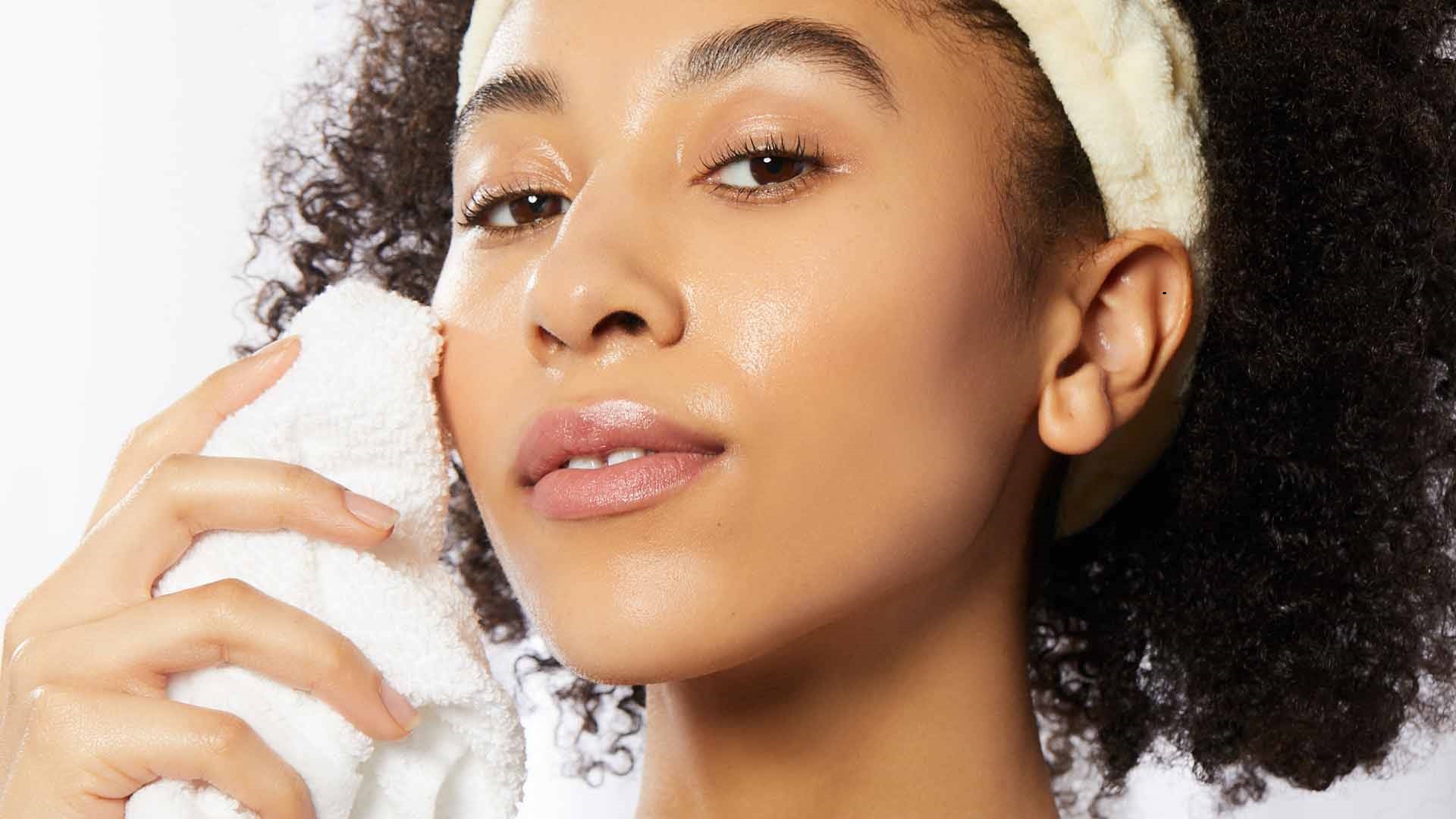 Woman using moisturizer on face