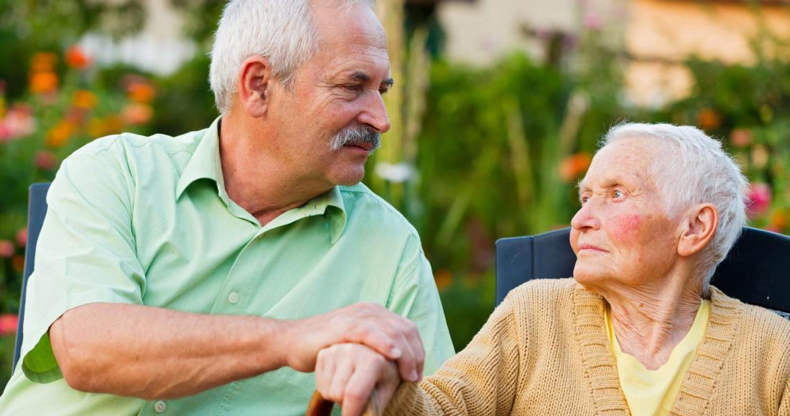  A person holding hands with a caregiver, symbolizing support and resilience in coping with the challenges of Alzheimer's Disease.