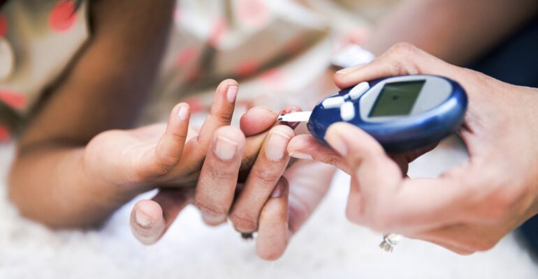 A hand checking other person diabetes with blood glucose meter