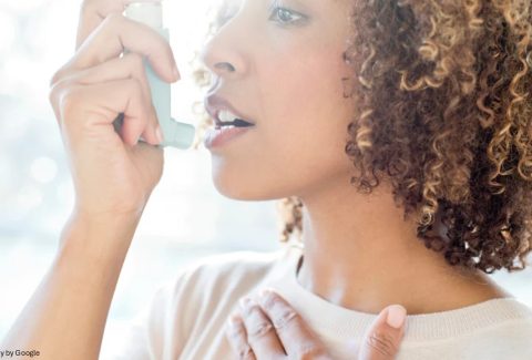 A lady using asthma inhaler