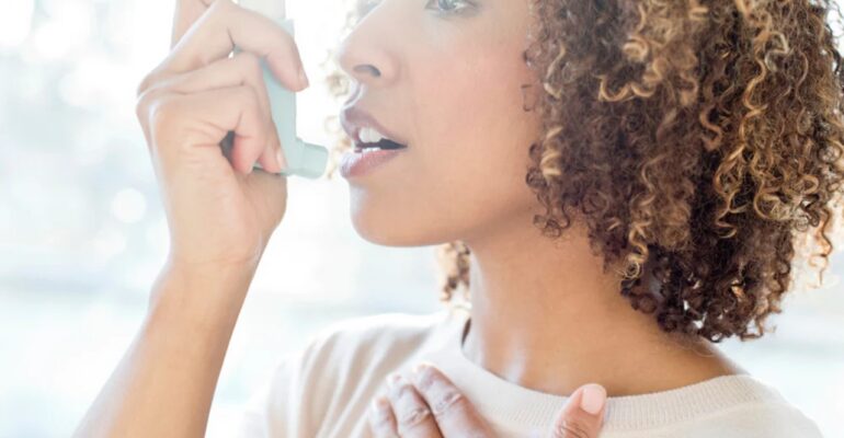 A lady using asthma inhaler