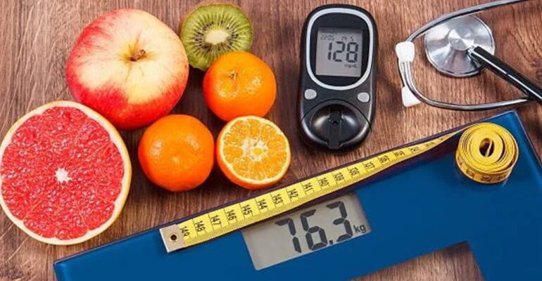 table with fruit, diabetes monitor & weight scale